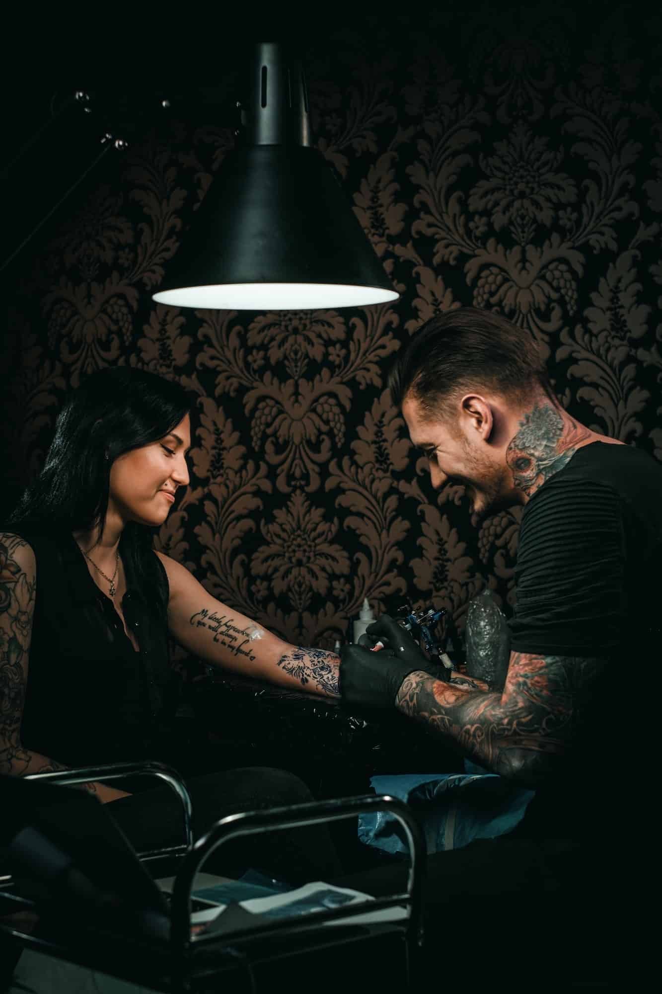 Professional tattoo artist makes a tattoo on a young girl